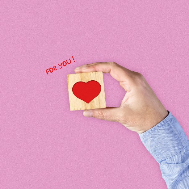 男人的手在木块上有一颗心。情人节贺卡快乐。图片下载