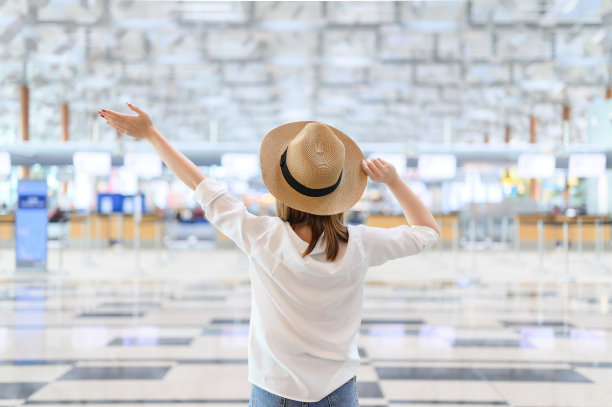 在机场航站楼举起双手的幸福女人图片下载