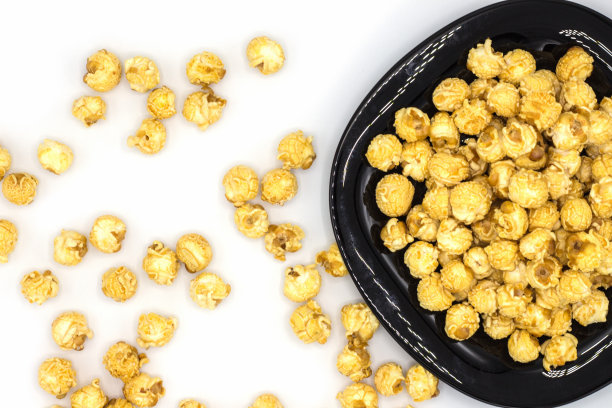 黑色盘子上的焦糖爆米花图片下载