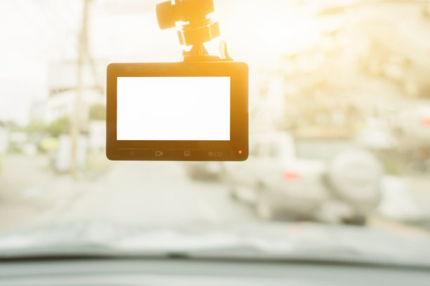汽车录像机安装在车窗上，有空白屏幕，拷贝空间，选择性对焦。日落时分,复古的颜色图片下载