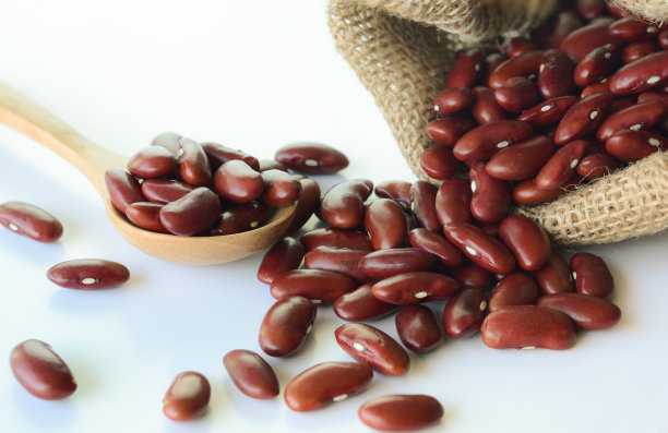 谷物红豆棕色袋和木勺白色背景。图片下载