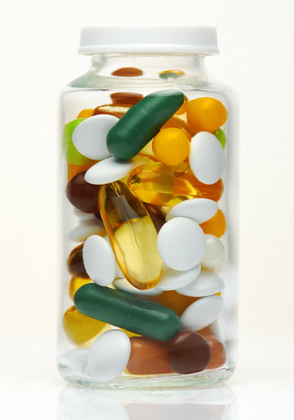 玻璃瓶内装满彩色药丸、片剂、维生素、药物、omega - 3鱼油、凝胶胶囊、保健品和食品补品。制药行业。药店宏观照片。图片下载