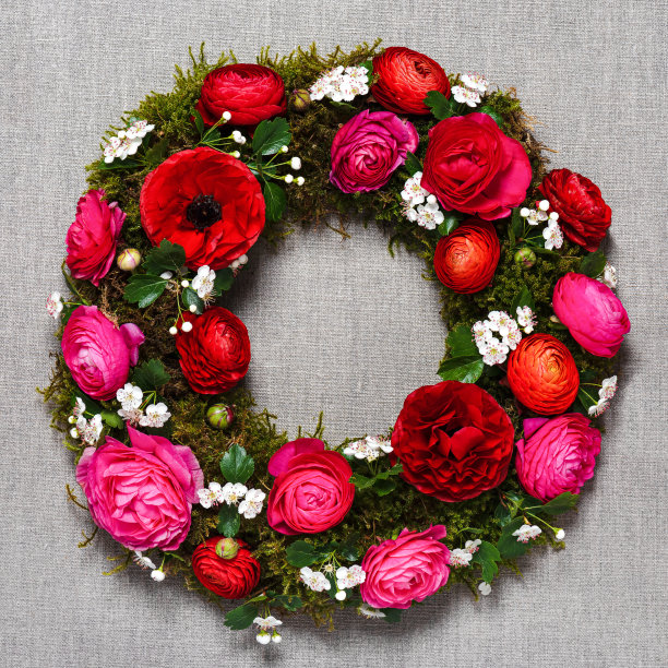 顶视图的手工花环与红色，粉红色毛茛花，驼鹿和白色山楂花在自然亚麻的背景。图片下载