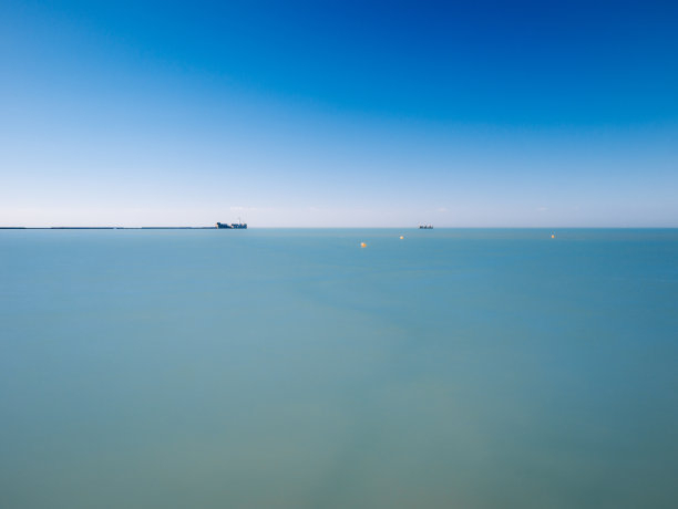 法国北部一个码头前平静的海面上有三个黄色浮标图片下载