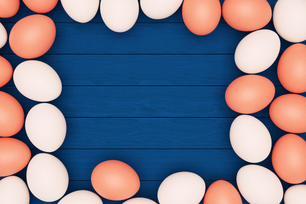 白色和棕色的鸡蛋躺在蓝色的木制背景上，复活节快乐，拷贝空间。图片下载