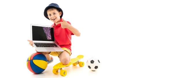 一个穿着黄色运动衫、红色短裤和白色运动鞋的巴拿马小男孩站在一枚黄色硬币上，上面有篮球、足球和一台笔记本电脑图片下载