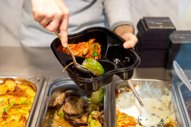 将即食食品倒入塑料容器的隔格中图片下载