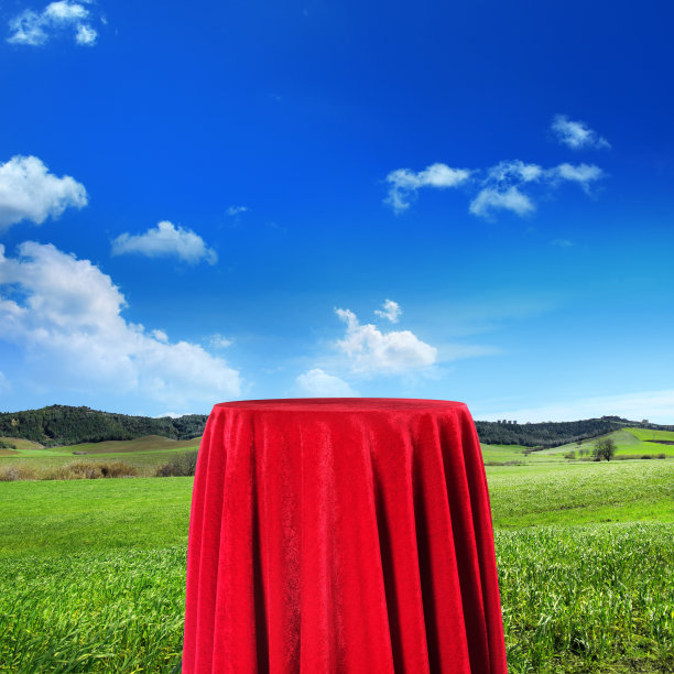 近距离看空红色天鹅绒覆盖基座在绿色景观图片下载