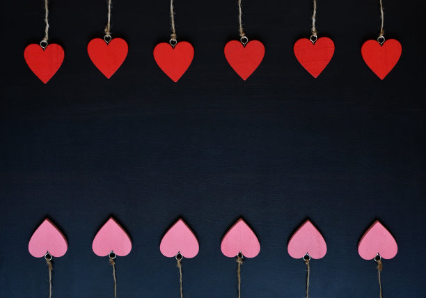 红色和粉色的木心在黑色的背景上。情人节的背景图片下载