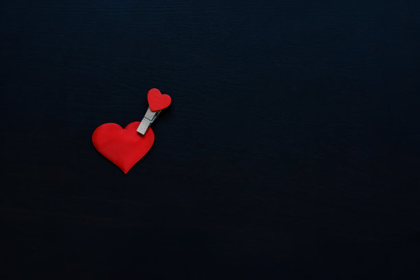 黑色背景上有很多衣夹上的木心。情人节图片下载