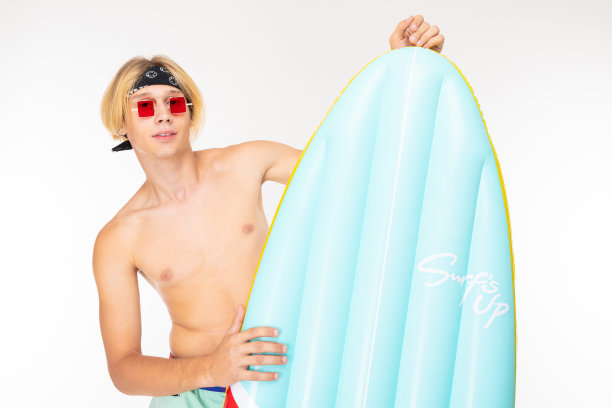 有魅力的金发男人，白色背景上的充气床垫是一个冲浪板图片下载