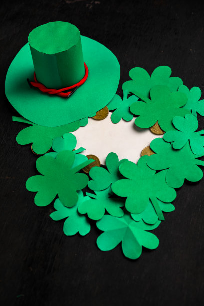 快乐圣帕特里克节绿色妖精帽子与金色覆盖巧克力硬币在黑色的木头背景，应用复古风格褪色滤镜。图片下载