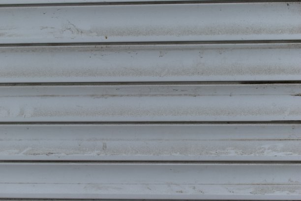 商店门上肮脏的白色百叶窗。图片下载