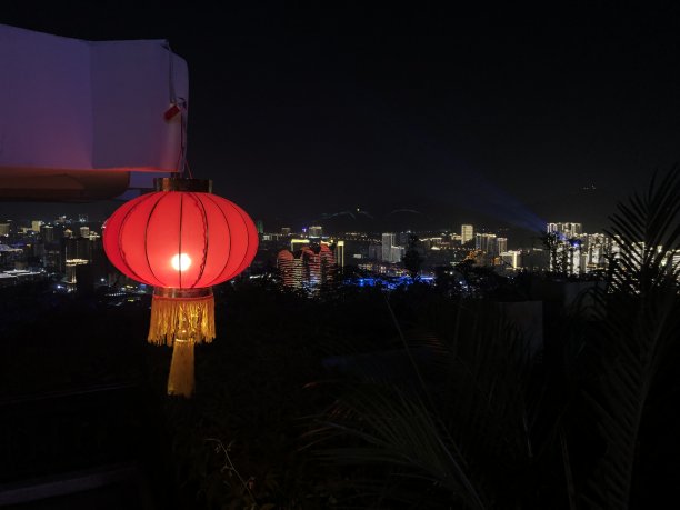 在三亚的灯光衬托下，中国传统的红灯笼在黑暗中闪闪发光图片下载