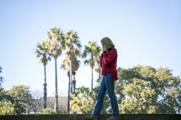 迷人的金发女人在用她的智能手机图片下载