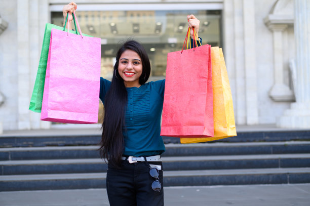 印度年轻的女孩拿着许多购物袋，而享受自己购物后的节日图片下载