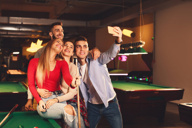 一群年轻人在一个晚上在台球俱乐部玩和自拍图片下载