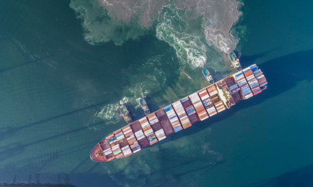 四艘拖船系泊在集装箱船上图片下载