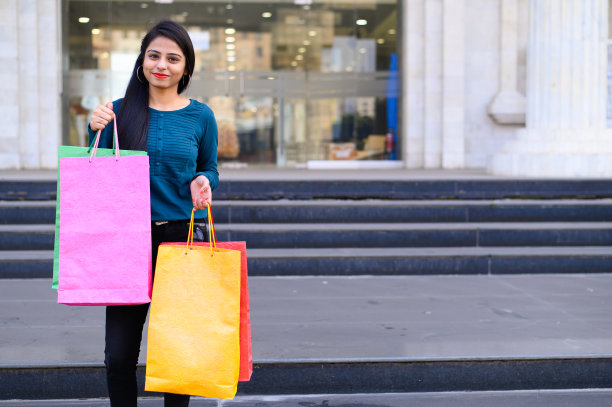 印度年轻的女孩拿着许多购物袋，而享受自己购物后的节日图片下载