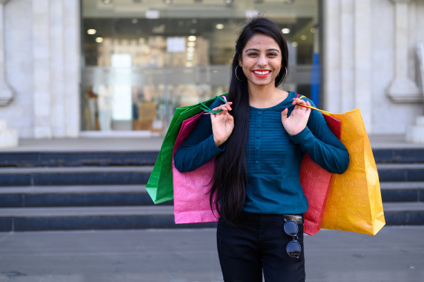 印度年轻的女孩拿着许多购物袋，而享受自己购物后的节日图片下载