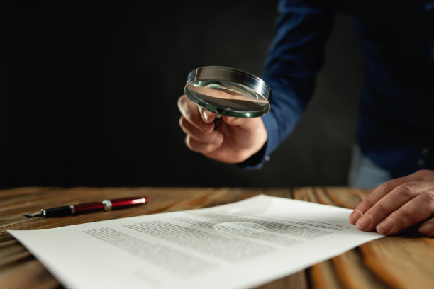 商人在签约前用放大镜看合同图片下载