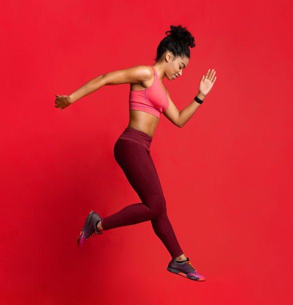 在红色背景下运动的年轻女子图片下载