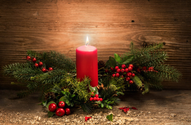 燃烧的圣诞红烛和节日圣诞装饰在质朴的木头桌子上。圣诞节的到来图片下载