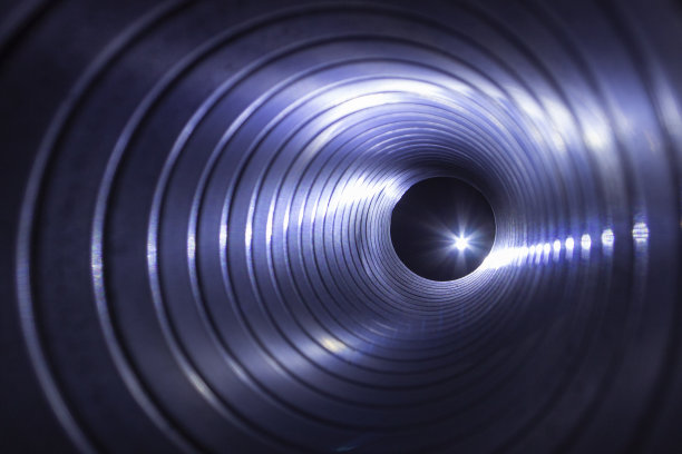 从背景灯上的镀锌钢风管内近距离观察排风扇，前后背景模糊，有散景效果图片下载