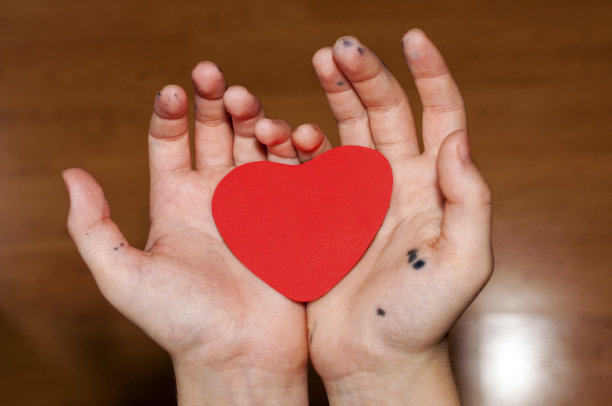 脏孩子们的手里拿着一颗红纸心。情人节的概念。文本。本空间图片下载