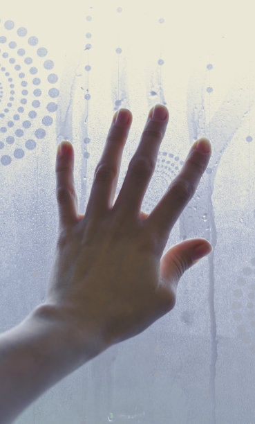 年轻女孩在湿玻璃上的手图片下载