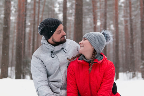 在冬季公园里，一对年轻的夫妇用爱的目光看着对方图片下载