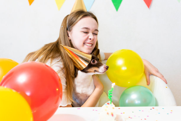 可爱的小有趣的狗与生日蛋糕和派对帽子庆祝生日图片下载