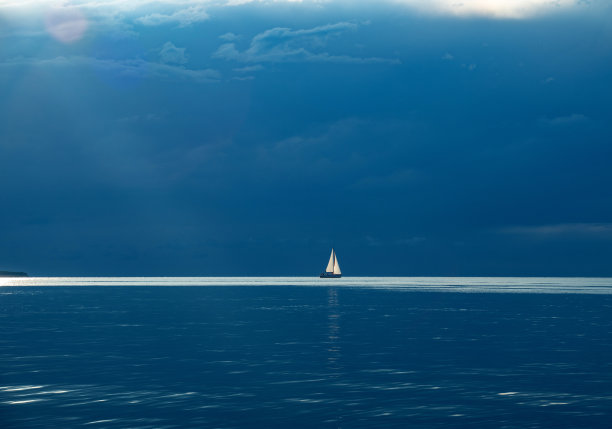 海上的帆船与暴风雨云在地平线上-库存照片图片下载