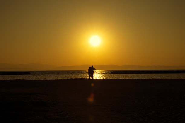 日落时分沙滩上的浪漫情侣图片下载