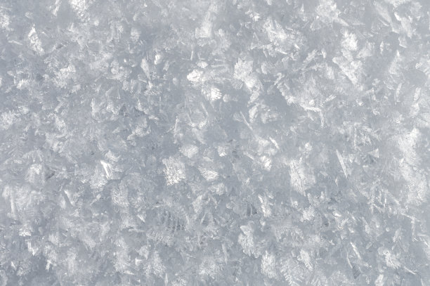 雪背景与详细的雪花。这是一张真正的雪晶体的微距照片:巨大的六边形对称的恒星枝晶，长长的优雅的图案和精致透明的结构图片下载