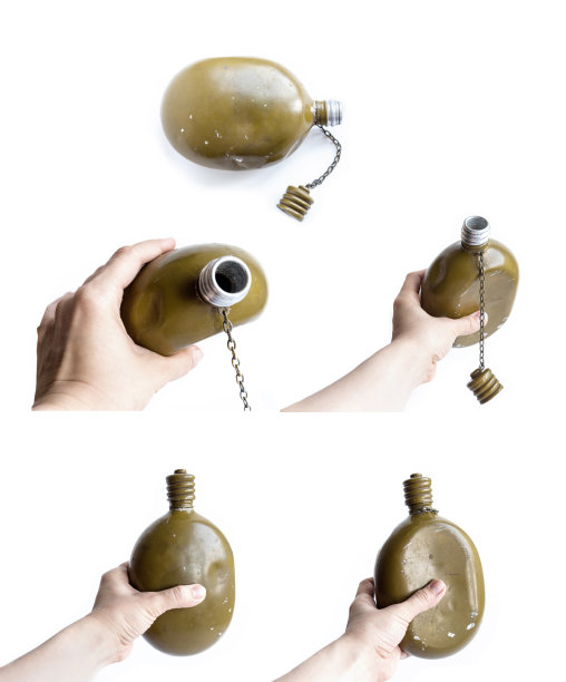 一套老旧的士兵烧瓶孤立在一个白色的背景。手里拿着一个绿色的军用烧瓶。图片下载