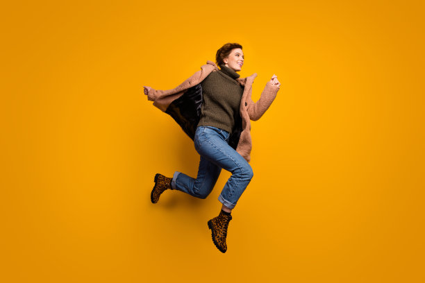 全长档案照片有趣的美丽的女士跳高冲购物中心穿休闲粉色外套套头牛仔裤豹纹鞋孤立的黄色背景图片下载