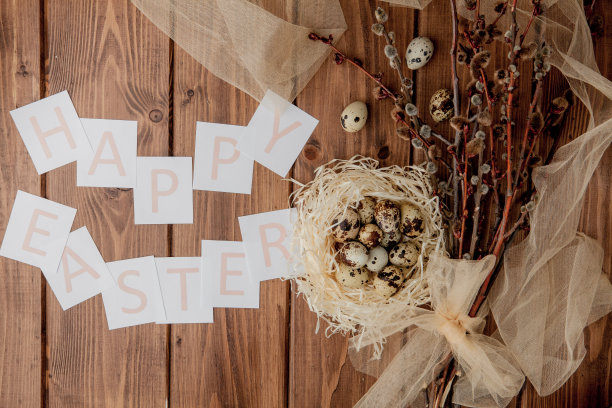 平躺构成鹌鹑蛋和卡片与文字复活节快乐的木制桌子。前视图。图片下载