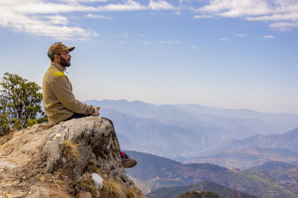在北阿坎德邦Kartik Swami徒步旅行期间，年轻的男性徒步者在山顶休息图片下载