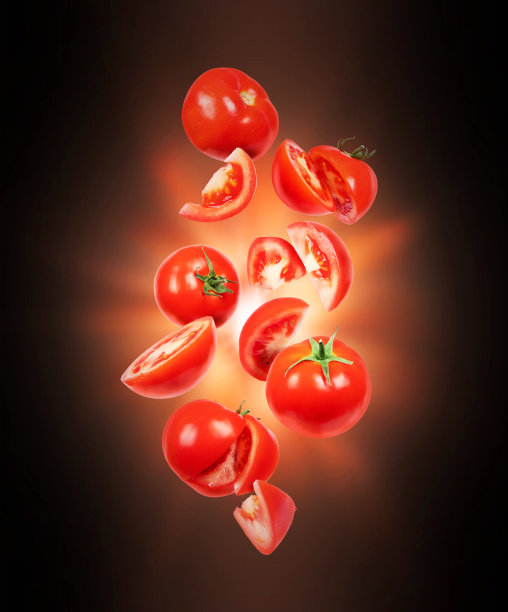 整个和切片的新鲜西红柿在黑暗中在空气中闪烁图片下载
