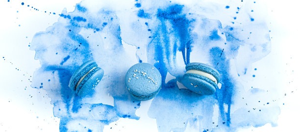 蓝色水彩背景上的甜点马卡龙。图片下载