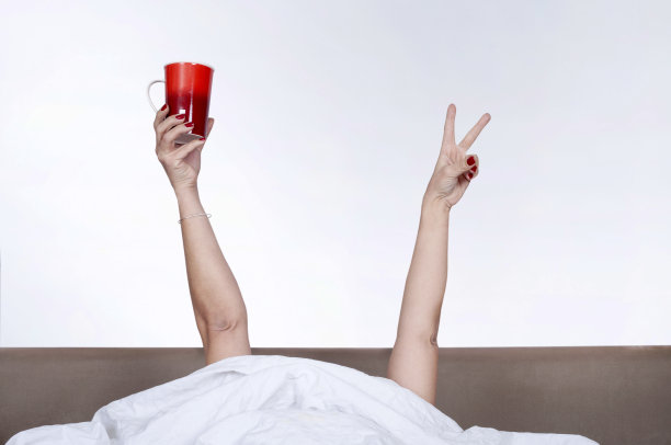 女人醒来后在床上喝咖啡图片下载