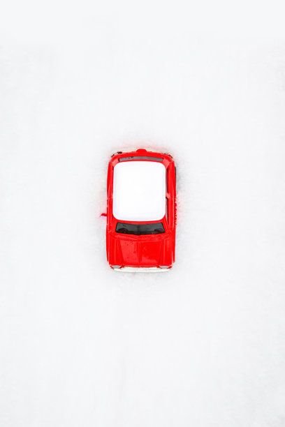 雪地里一辆红色儿童玩具车的俯视图。垂直位置图片下载