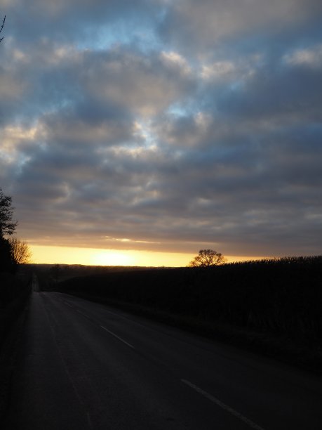 傍晚的日落，金色的太阳在地平线上和云图片下载
