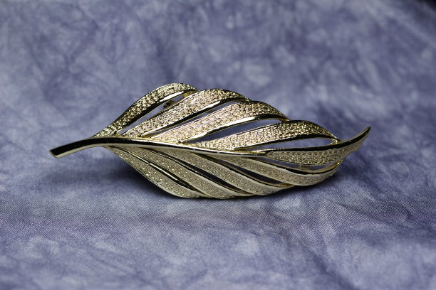 复古金叶胸针在灰色丝绸背景图片下载