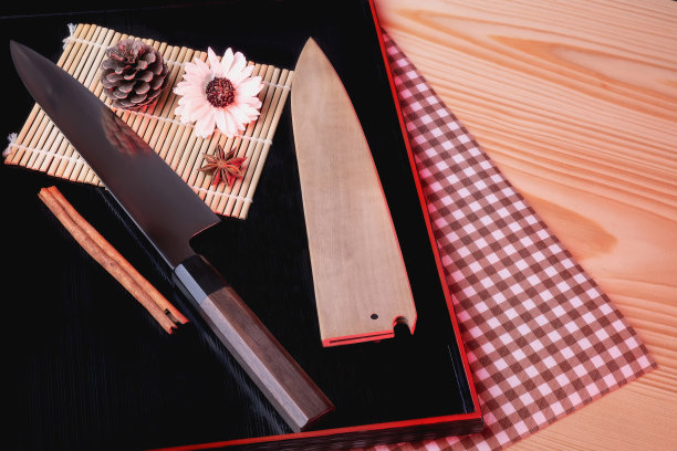 日本刀放在黑色的木托盘上，放在棕色的木桌子上。靠近美丽的花朵图片下载