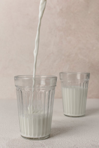 一股牛奶流进玻璃杯的画面。图片下载