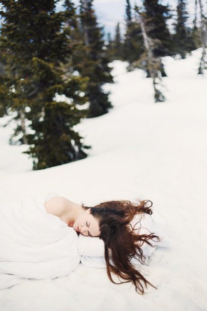 艺术肖像美丽的女人与长棕色头发滑在雪坏图片下载