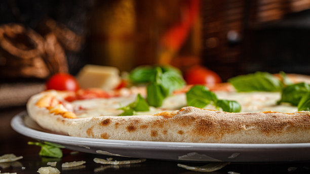 talian菜。经典的意大利玛格丽塔披萨配罗勒，奶酪和西红柿。在餐馆里用白盘子上菜。背景图像，复制空间文本图片下载