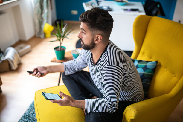 在家里用电视和智能手机放松早晨图片下载